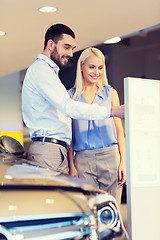 Image showing happy couple buying car in auto show or salon