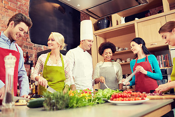 Image showing happy friends and chef cook cooking in kitchen