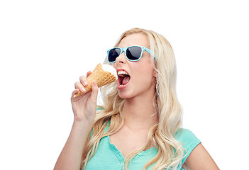 Image showing happy young woman in sunglasses eating ice cream