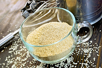 Image showing Flour sesame in cup with sieve on board