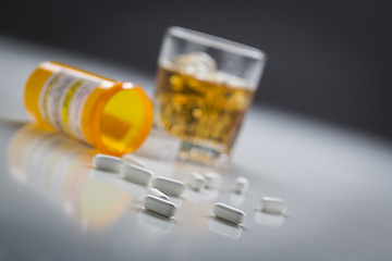 Image showing Prescription Drugs Spilled From Fallen Bottle Near Glass of Alco