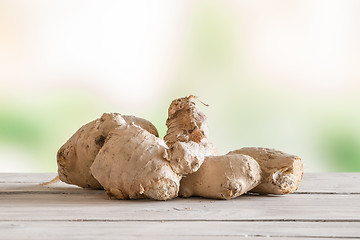 Image showing Raw ginger on a wooden table