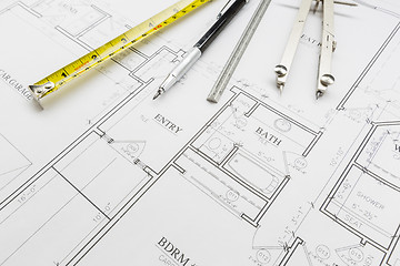 Image showing Measuring Tape, Pencil, Ruler and Compass Resting on House Plans