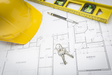 Image showing Hard Hat, Pencil, Level and Keys Resting on House Plans