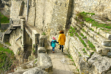 Image showing Girl with mother walking along medieval wall