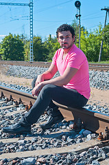 Image showing One man in pink on train tracks