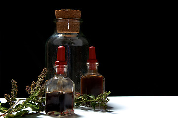 Image showing three glass bottles with herbal extracts and dried herbs at eye 