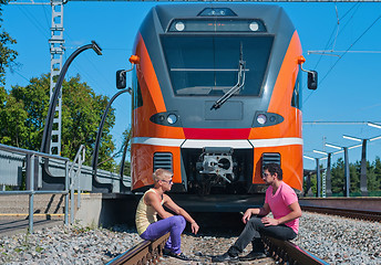 Image showing Young trendy guys in front of train