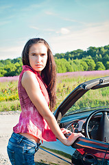 Image showing Gorgeous brunette female standing near car