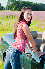 Image showing Beautiful brunette female standing near car