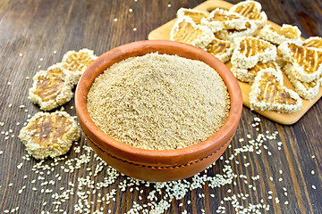 Image showing Flour sesame in clay bowl with cookies on board