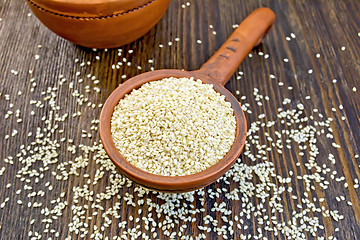 Image showing Sesame seeds in clay ladle on board