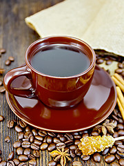 Image showing Coffee in brown cup with sugar and bag on dark board