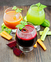 Image showing Juice beet and cucumber in wineglass on dark board