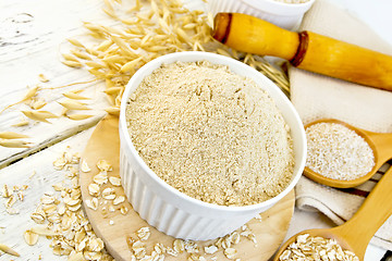 Image showing Flour oat in white bowl with flakes on light board