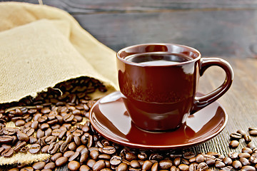 Image showing Coffee in brown cup with bag on board