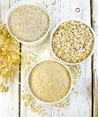 Image showing Flour oat in white bowl with bran and flakes on board top