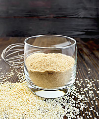Image showing Flour sesame in glassful on dark board