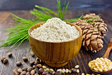 Image showing Flour cedar in bowl with nuts on wooden board