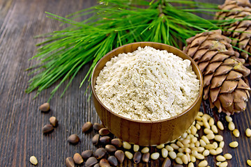 Image showing Flour cedar in wooden bowl with nuts on board