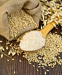 Image showing Flour oat in spoon with grains on board