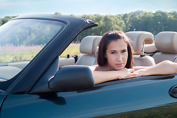 Image showing Beautiful brunette female sitting in car