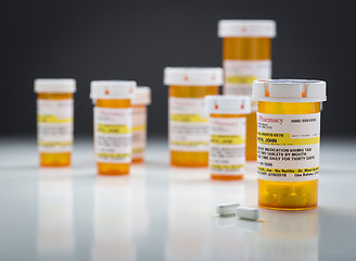 Image showing Medicine Bottles and Pills on Reflective Surface With Grey Backg