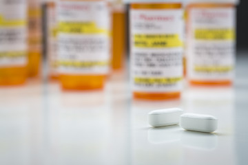 Image showing Medicine Bottles and Pills on Reflective Surface With Grey Backg