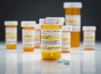 Image showing Medicine Bottles and Pills on Reflective Surface With Grey Backg