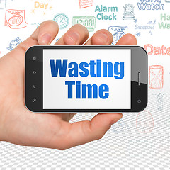 Image showing Time concept: Hand Holding Smartphone with Wasting Time on display