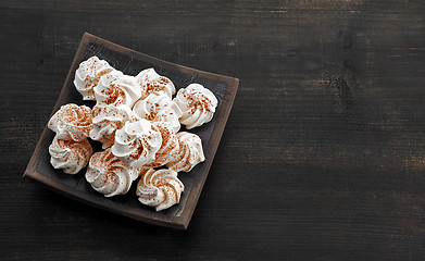 Image showing meringue cookies on dark wooden table