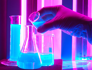 Image showing hand holding laboratory flasks