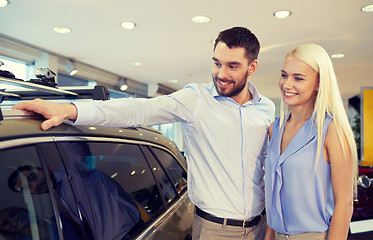 Image showing happy couple buying car in auto show or salon