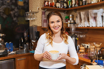 Image showing happy barista woman with latte at coffee shop