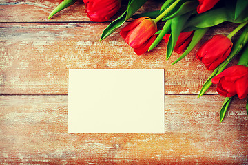 Image showing close up of red tulips and blank paper or letter