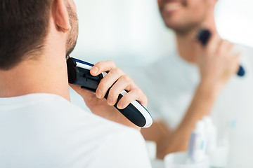 Image showing close up of man shaving beard with trimmer