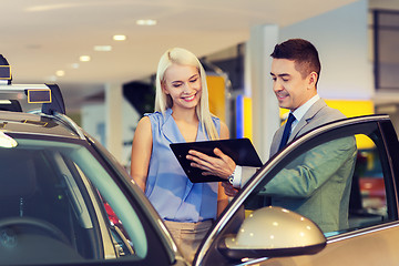 Image showing happy woman with car dealer in auto show or salon