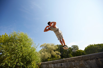 Image showing sporty young man jumping in summer park