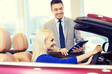 Image showing happy woman with car dealer in auto show or salon