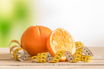 Image showing Orange fruit with a yellow measure tape