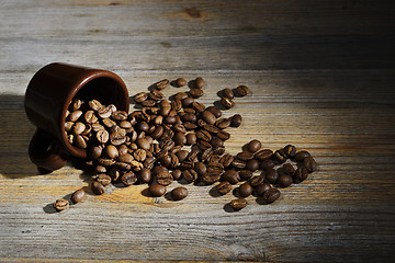 Image showing cup and coffee beans on a wooden background