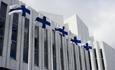 Image showing waving Finnish flags against of The Finlandia Hall