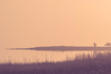 Image showing Calm lake in a misty sunrise