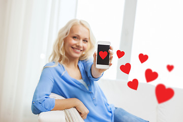 Image showing smiling woman with smartphone at home