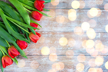 Image showing close up of red tulips on wooden background