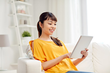 Image showing happy young asian woman with tablet pc at home