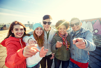 Image showing happy teenage friends pointing fingers on street