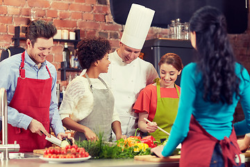 Image showing happy friends and chef cook cooking in kitchen