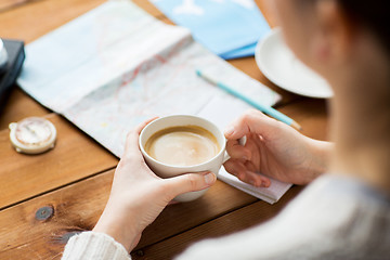 Image showing close up of hands with coffee cup and travel stuff