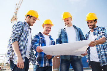 Image showing group of builders with tablet pc and blueprint